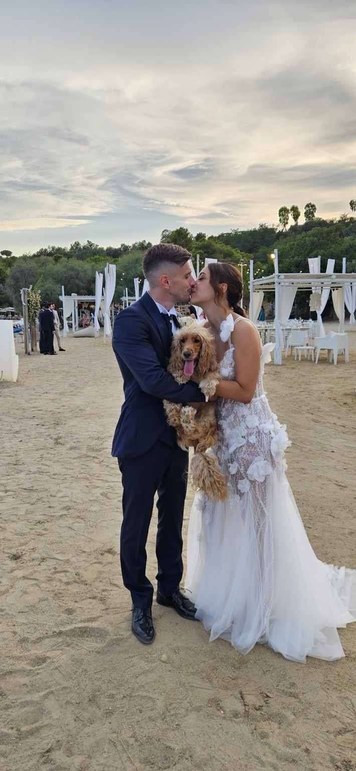 Sposi che abbracciano il proprio cane nel giorno del matrimonio